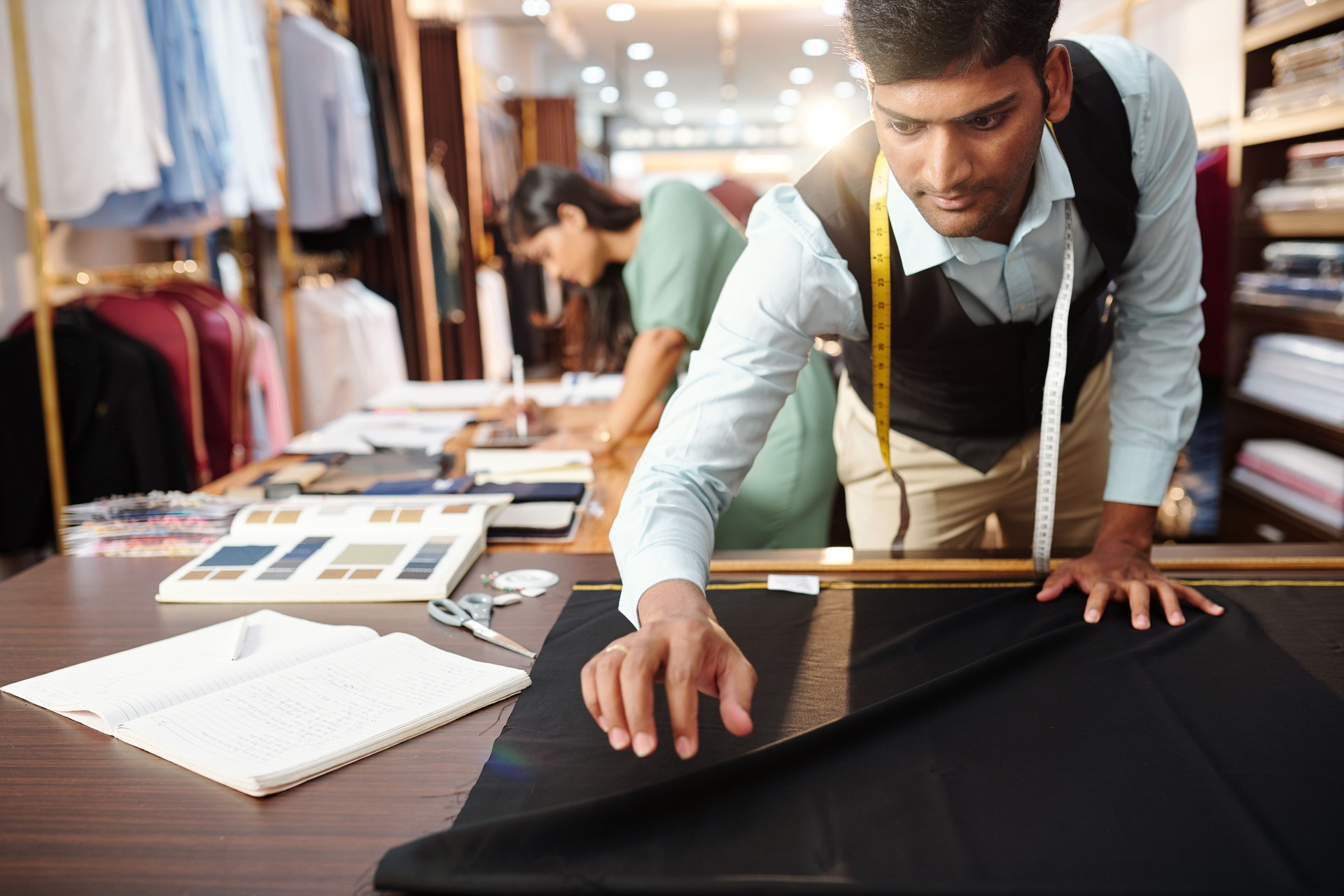 Tailor laying out black fabric